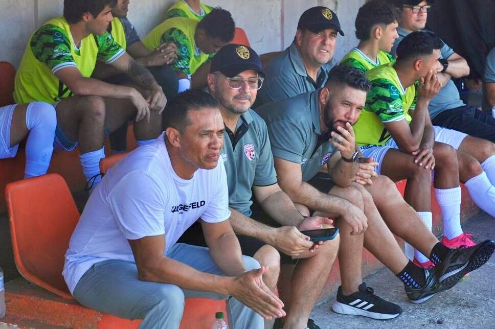 Entrenadores en los banquillos previo al inicio del juego