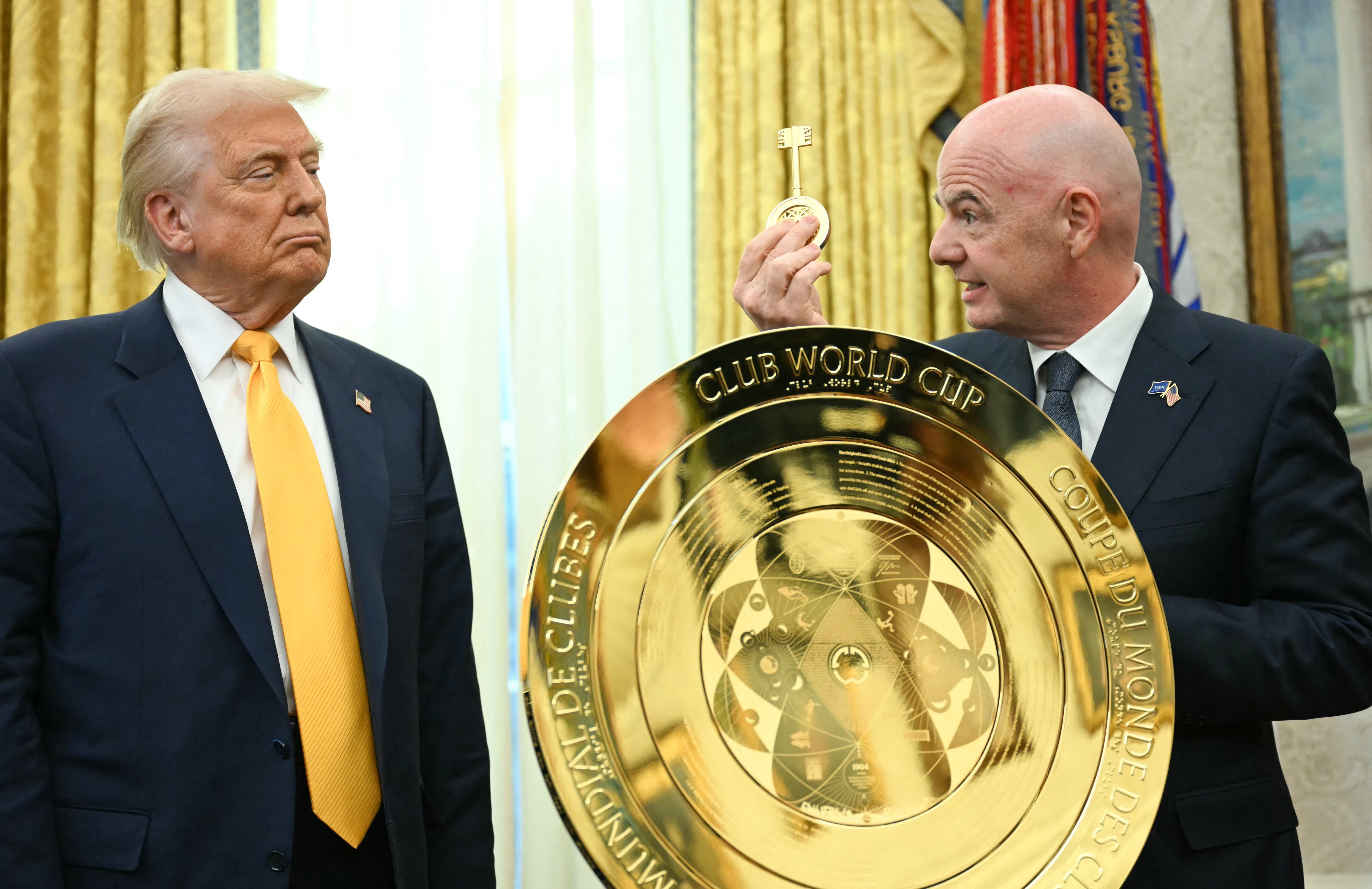 Donald Trump observa con atención ese trofeo con llave del Mundial de Clubes que le muestra el presidente de la FIFA, Gianni Infantino.