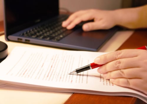 Texto borroso y revisión de un documento, simbolizando los errores de escritura y la corrección.