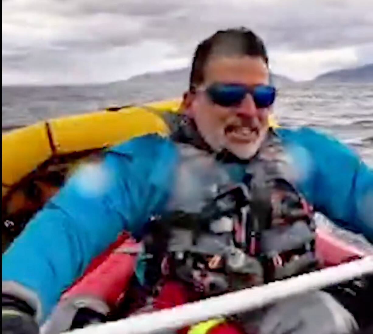 Dell Simancas, un anestesista de 49 años, mientras remaba hacia la orilla con su hijo agarrado a su bote. Fotografía: