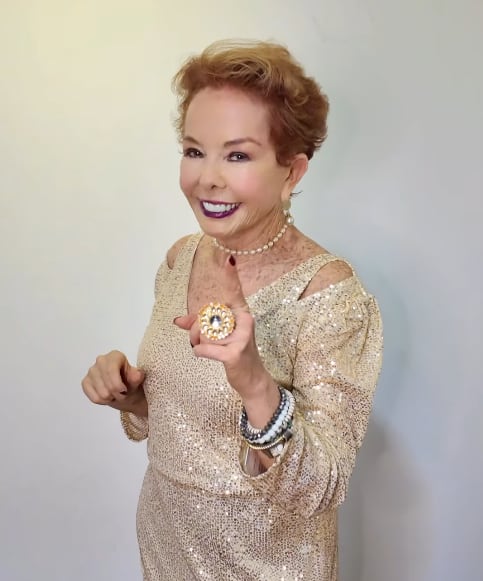 Amanda Moncada, creadora de contenido y experta en moda, vistiendo un elegante vestido dorado y sonriendo hacia la cámara.