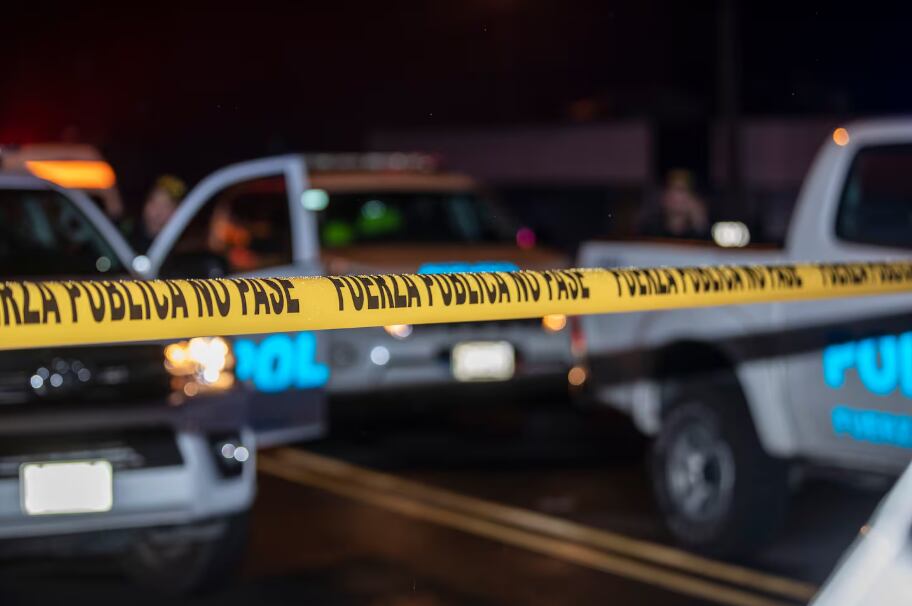 En la imagen una cinta de policía y pick-ups de fuerza pública