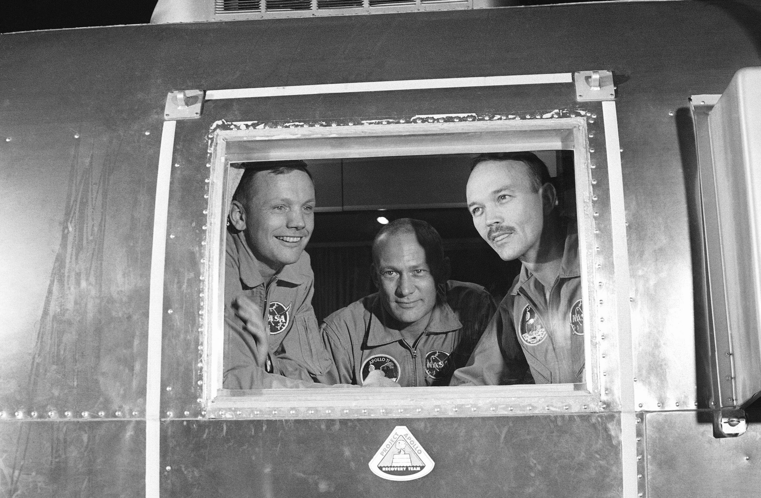 FILE - In this July 27, 1969 file photo, Apollo 11 crew members, from left, Neil Armstrong, Buzz Aldrin and Michael Collins sit inside a quarantine van in Houston. (AP Photo)