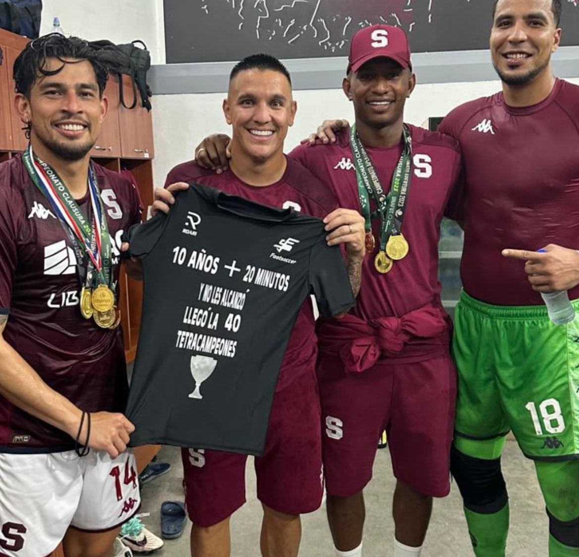 Ariel Rodríguez, David Guzmán, Fidel Escobar y Esteban Alvarado muestran una camiseta en la que presumen de la cantidad de campeonatos del Deportivo Saprissa sobre su eterno rival, la Liga Deportiva Alajuelense.