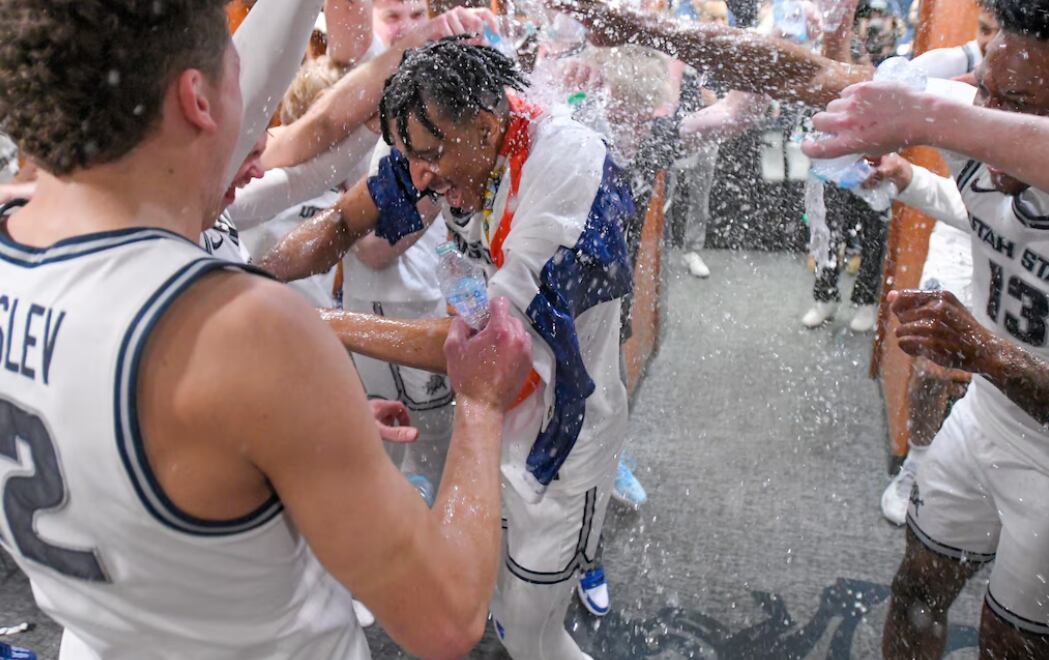El tico Ian Martínez lució la bandera de Costa Rica en medio de la celebración con sus compañeros de Utah State University. Martínez concretó la canasta de la victoria.