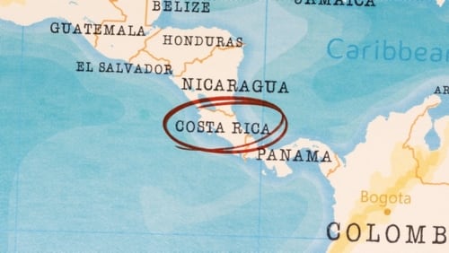 Mapa de Centroamérica sobre fondo celeste con el nombre de Costa Rica enmarcado en un círculo rojo, ilustrando la posición de Costa Rica en el Istmo para atraer inversión extranjera directa.