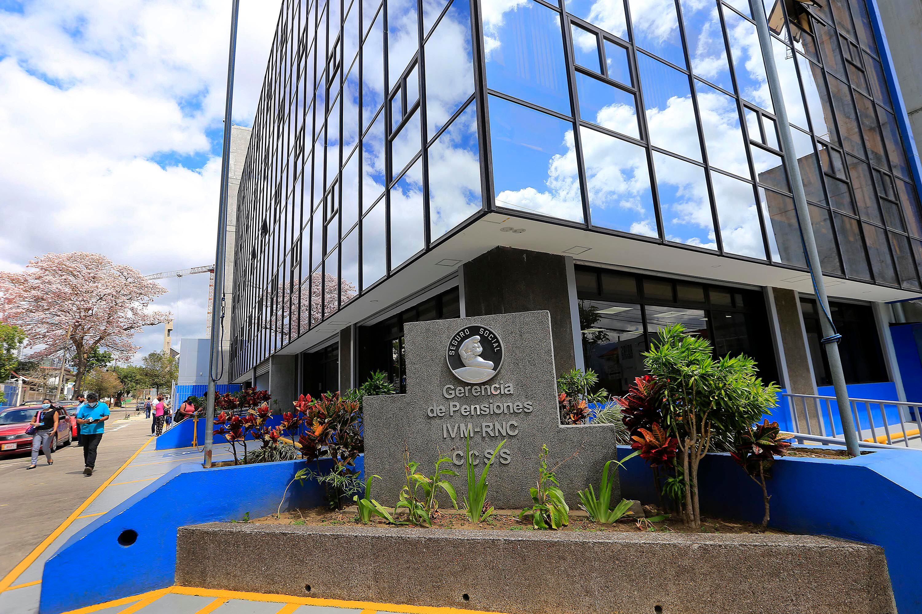 Vista exterior del edificio de la Gerencia de Pensiones de la Caja Costarricense de Seguro Social (CCSS), con un letrero destacado del Régimen de Invalidez, Vejez y Muerte (IVM).