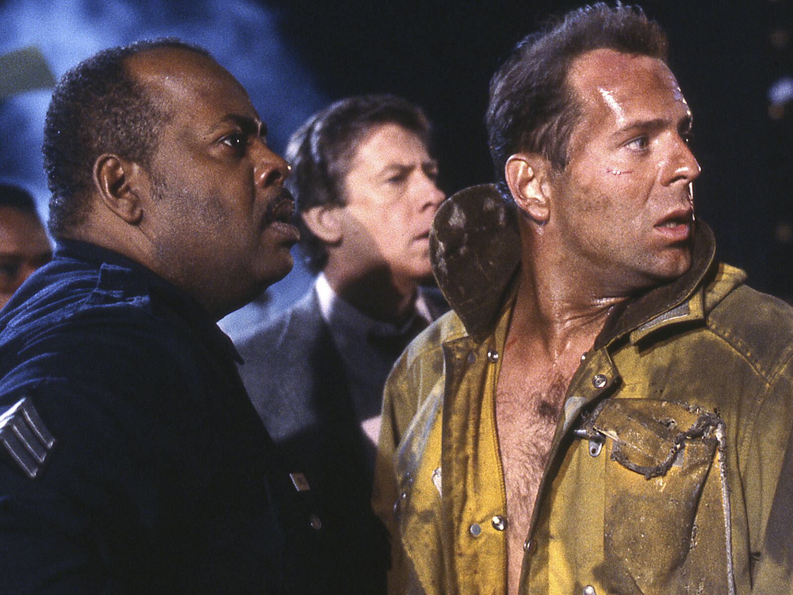 Escena del final de 'Duro de matar' con un policía a la izquierda y Bruce Willis a la derecha