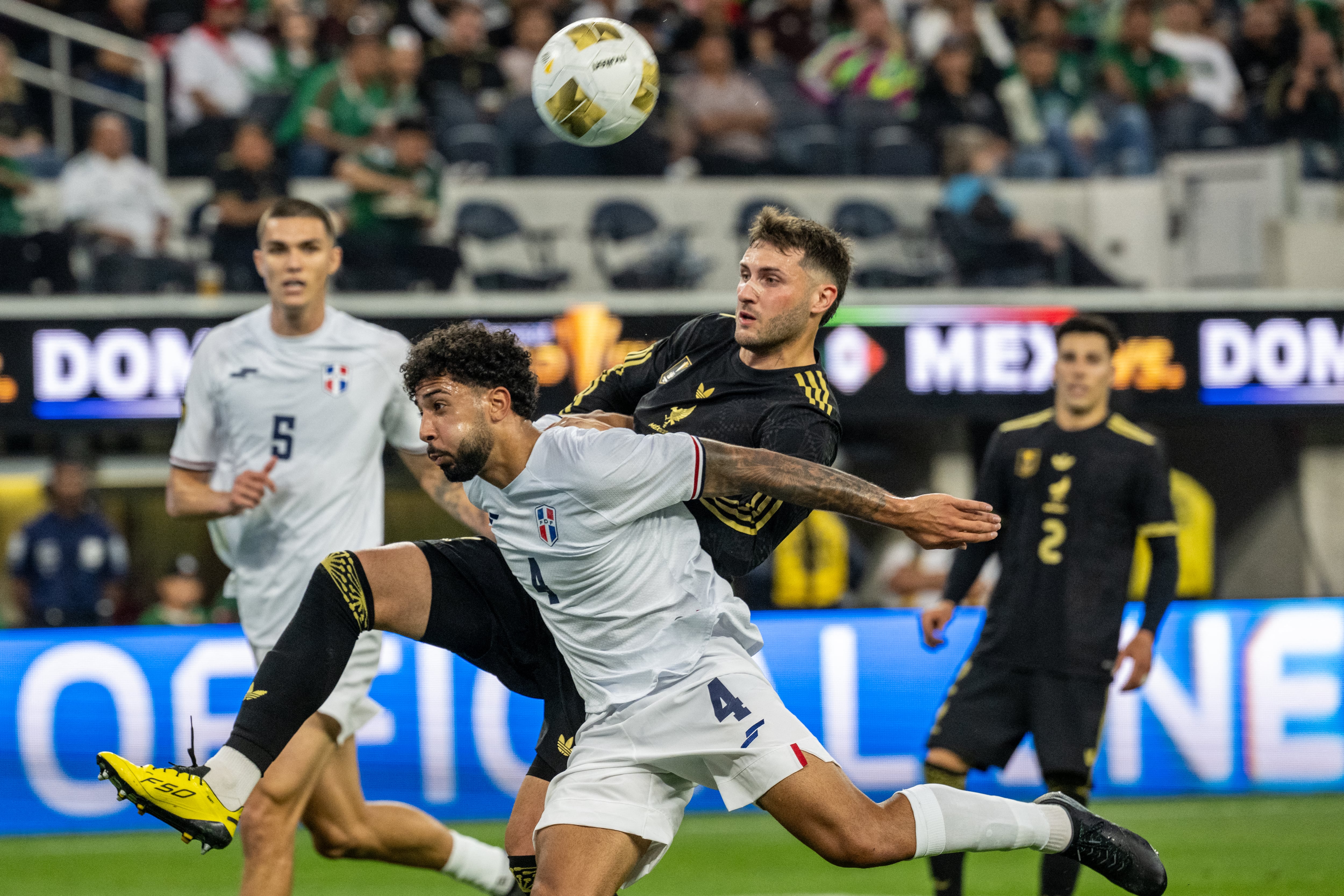 El mexicano Santiago Giménez batalla con Edgar Pujol de República Dominicana, durante el primer partido de la Copa Oro 2025, disputado en el SoFi Stadium de Inglewood, California.