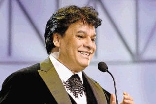 Juan Gabriel en primer plano hablando al micrófono.