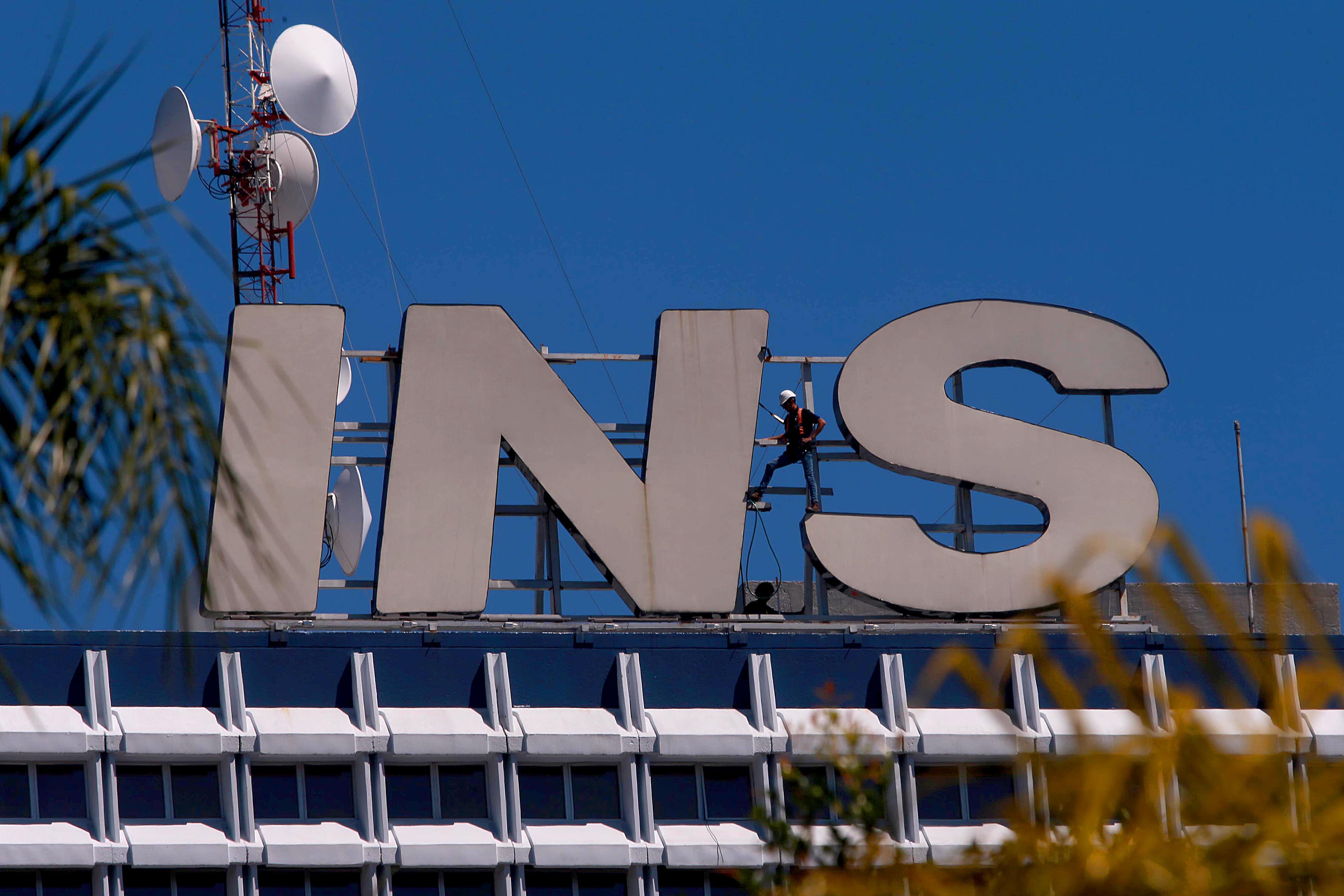 12/02/2024 San José. Desde lo más alto del edificio central del Instituto Nacional de Seguros (INS), un trabajador, en labores de mantenimiento, lavaba y limpiaba las características letras del logotipo.