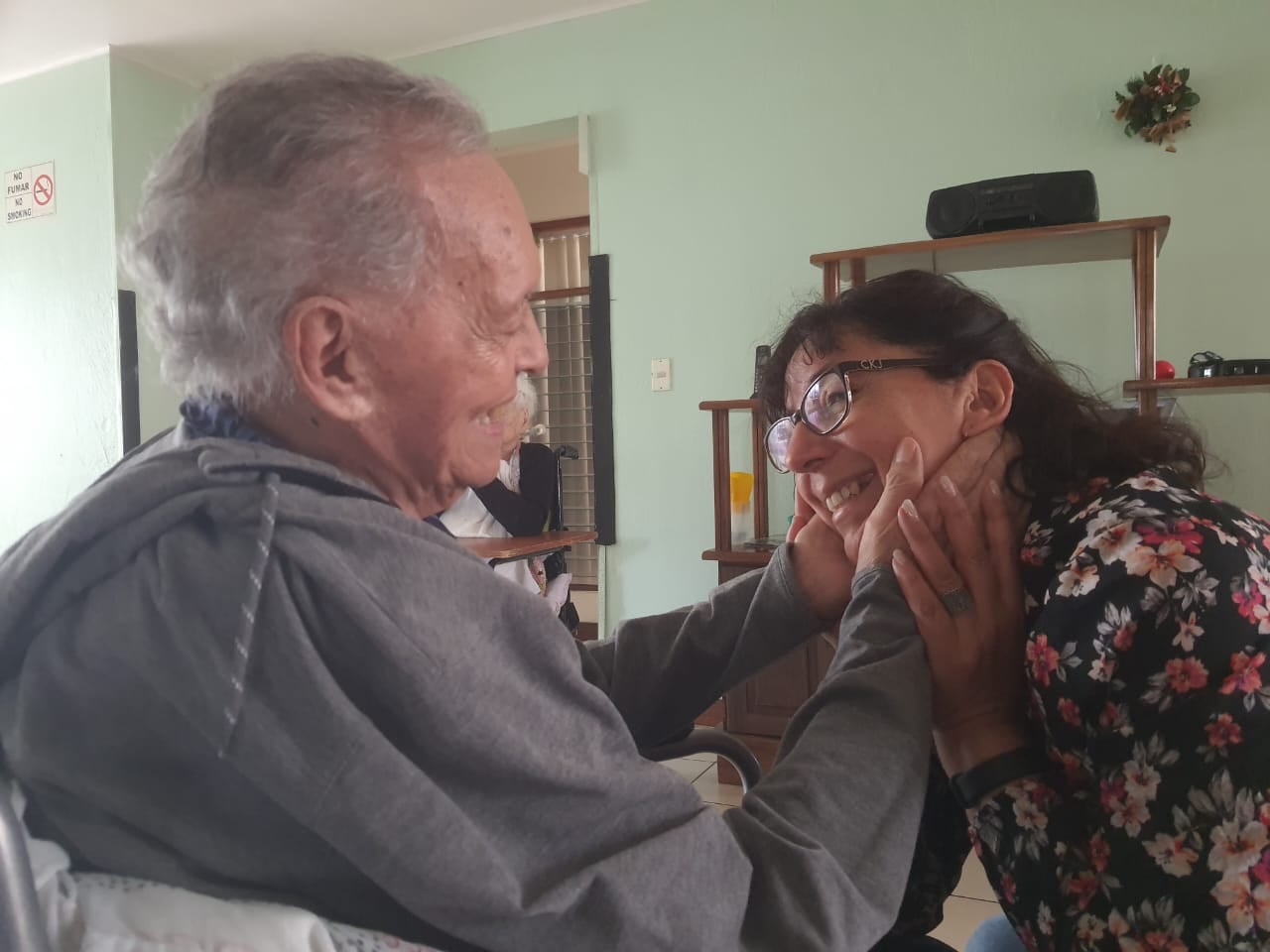 El actor Lucho Barahona de 92 años acaricia la cara de su sobrina, la señora Patricia Castillo en el hogar de ancianos Casa de Ángeles en Curridabat.