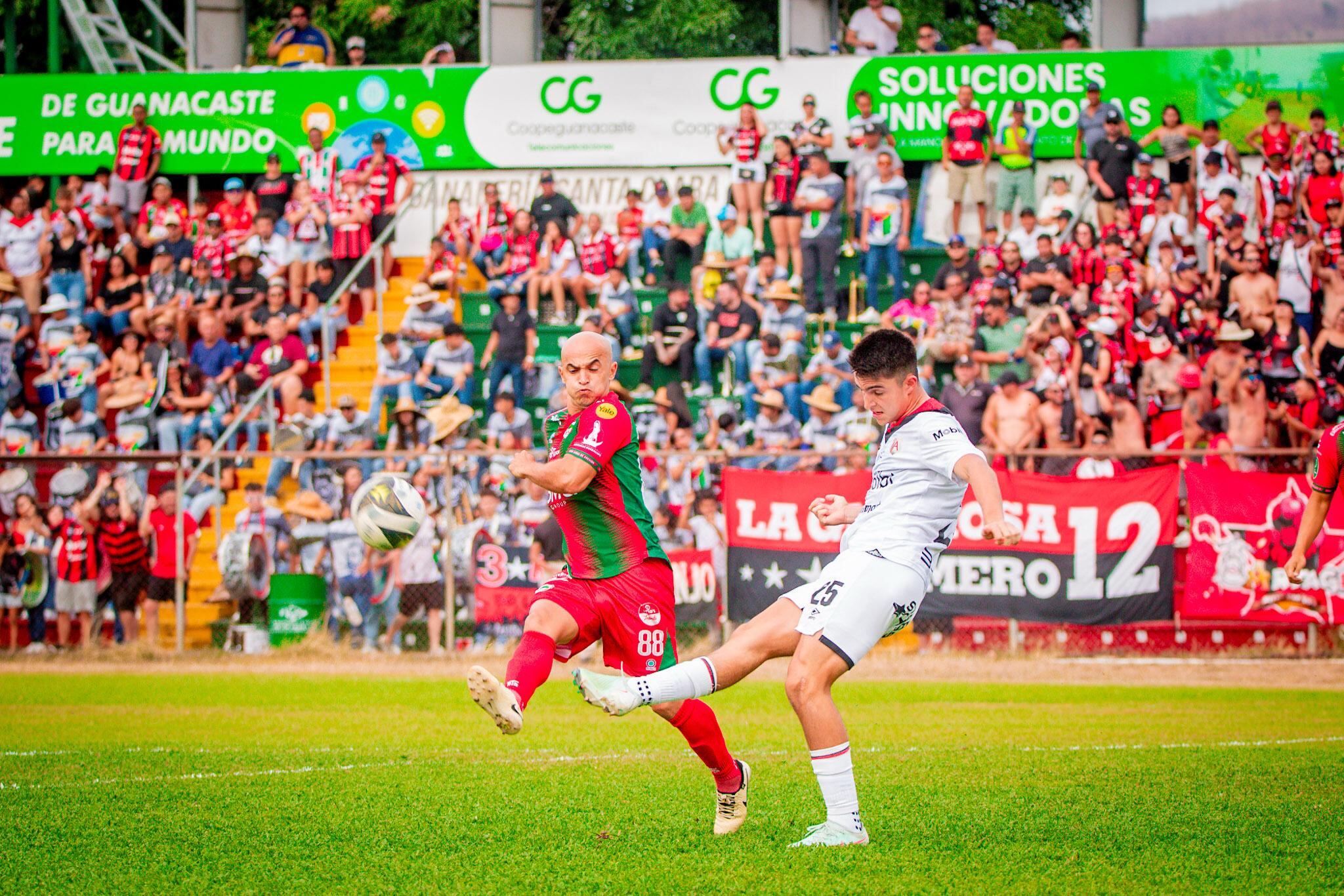 Santiago van der Putten despeja un balón ante el acecho de Starling Vega, en el partido entre Guanacasteca y Liga Deportiva Alajuelense.