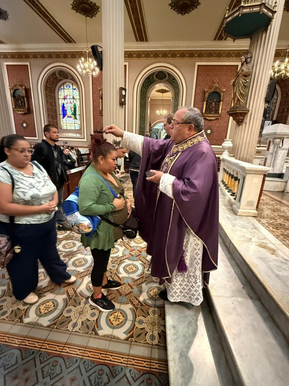 El padre Germán Rodríguez Smith impone la ceniza a doña Katherine Contreras en la misa de las 6:30 de la mañana del Miércoles de Ceniza 2026, el 18 de febrero.
