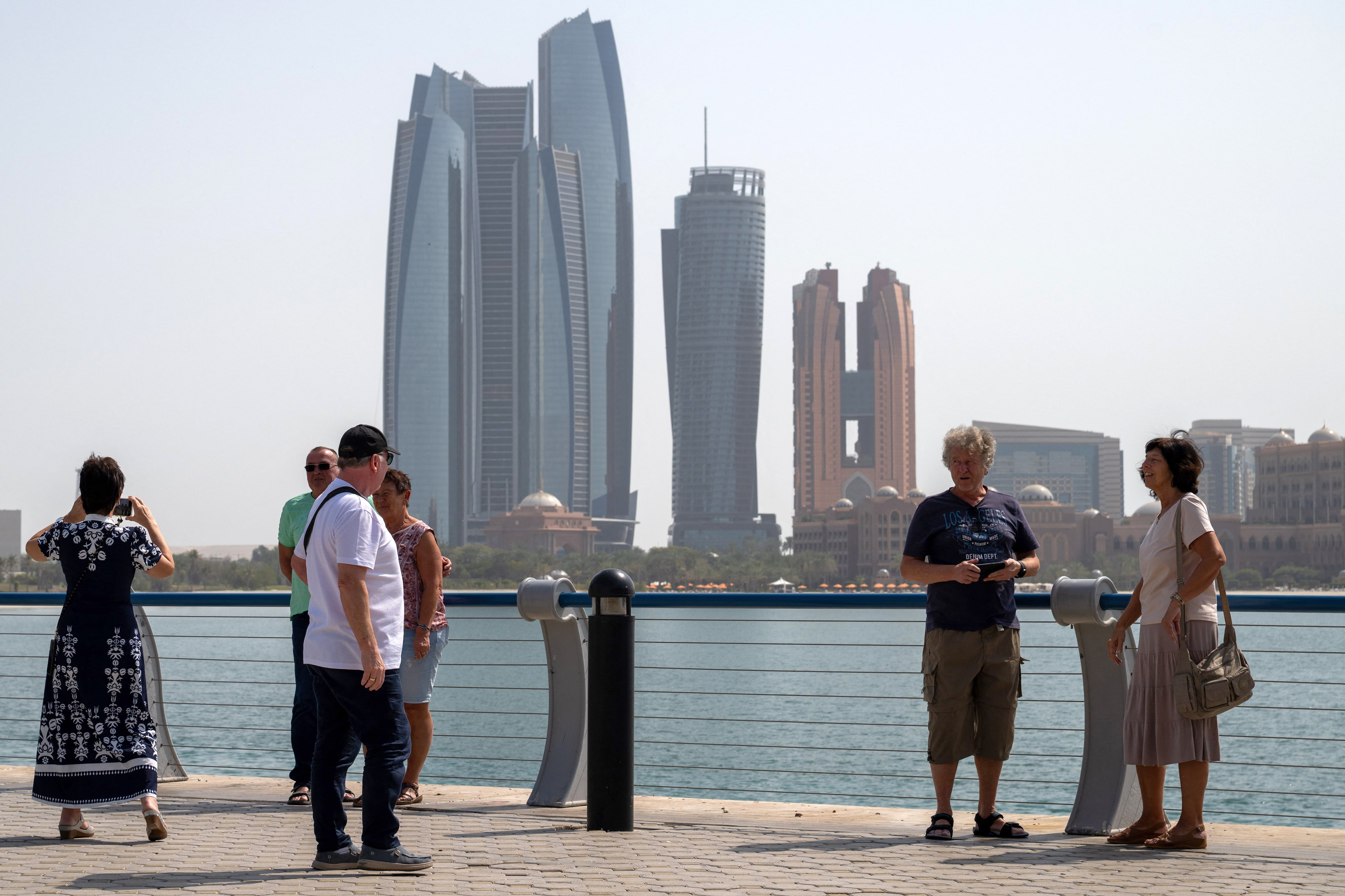 Turistas se detienen cerca de las Etihad Towers en Abu Dabi el 1 de marzo de 2026. La campaña de represalias de Irán con misiles y drones en el Golfo ha dejado tres muertos y 58 heridos en Emiratos Árabes Unidos desde su inicio.