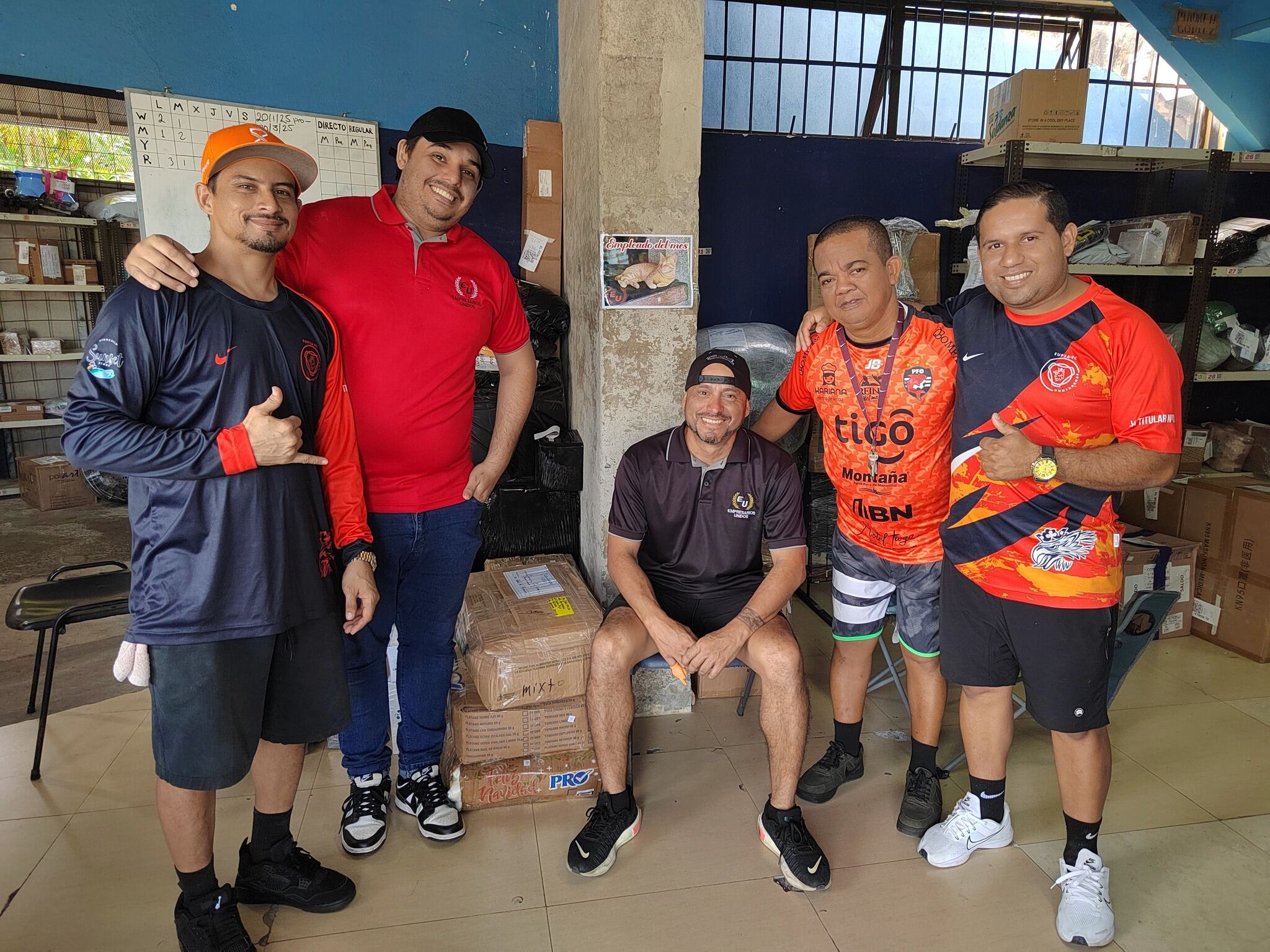Ricky es un gatico y Negro un perrito, que viven en la sección de Encomiendas de El Roble de Puntarenas de Transportes Unidos. En la foto, de izquierda a derecha: a Mario Barrantes (Cócoro), Kenneth Cascante (Yiyo), Wally Berrocal (Messi), Minor Obando (Periquito) y Reanthony Hernández (ProfeRea).