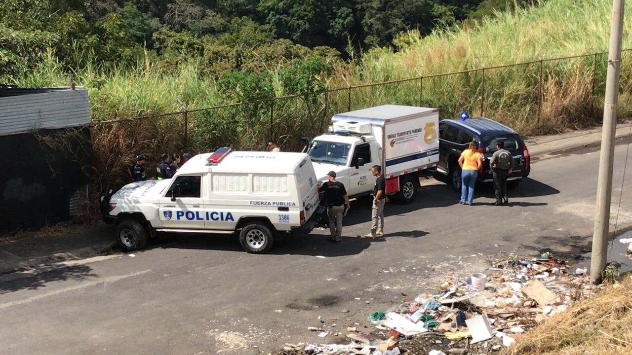 A las 10:35 a. m. de este sábado los agentes del OIJ con apoyo de la Fuerza Pública procedían al levantamiento del cuerpo que quedó en la vía pública, junto a una malla tipo ciclón. Foto: Alonso Tenorio.