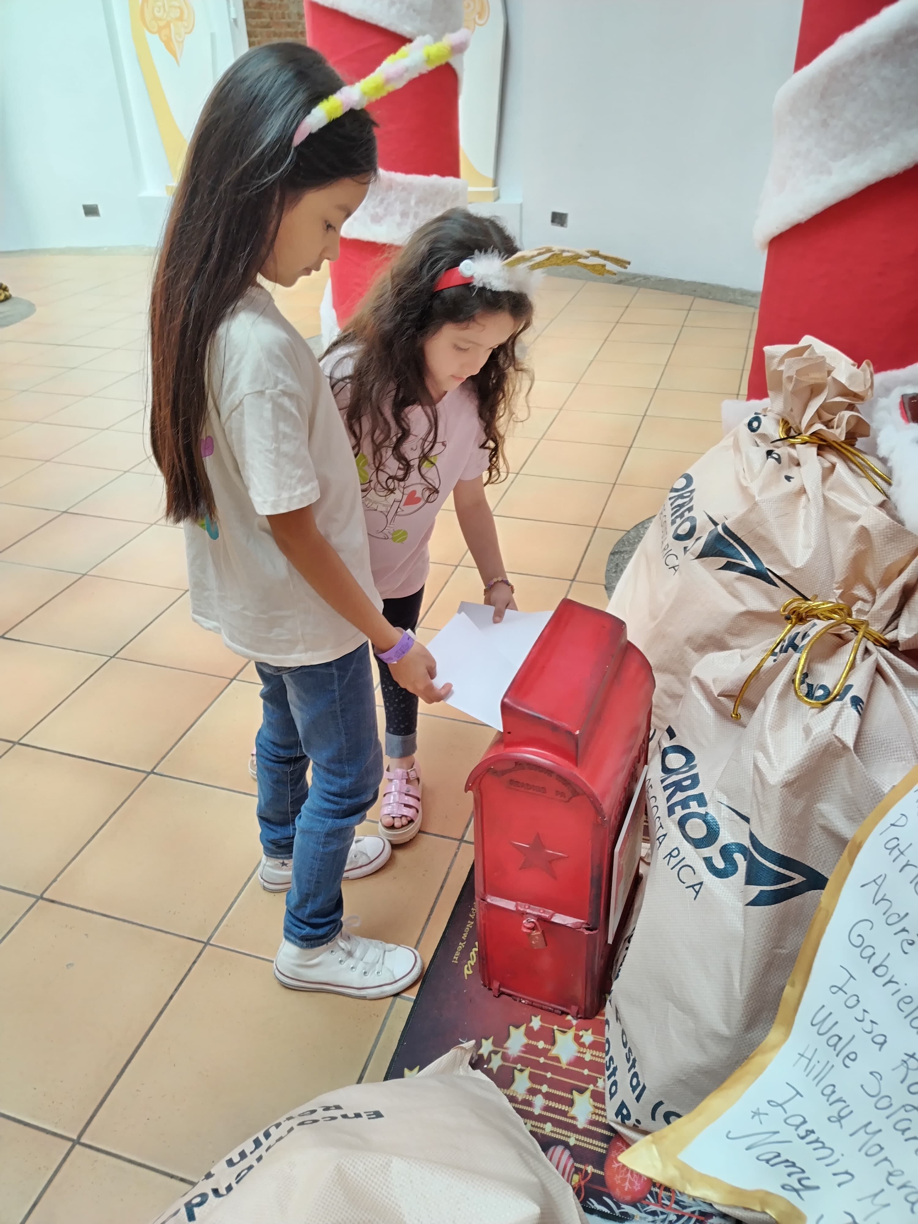 Este 2023 el Niñito Jesús y Santa sí están recibiendo las cartitas de los niños para Navidad. El Museo de los Niños puso una sucursal para entregar las cartitas. En la foto, las niñas Valentira Quirós y Luigina Pastor hacen sus cartitas al Niñito.
