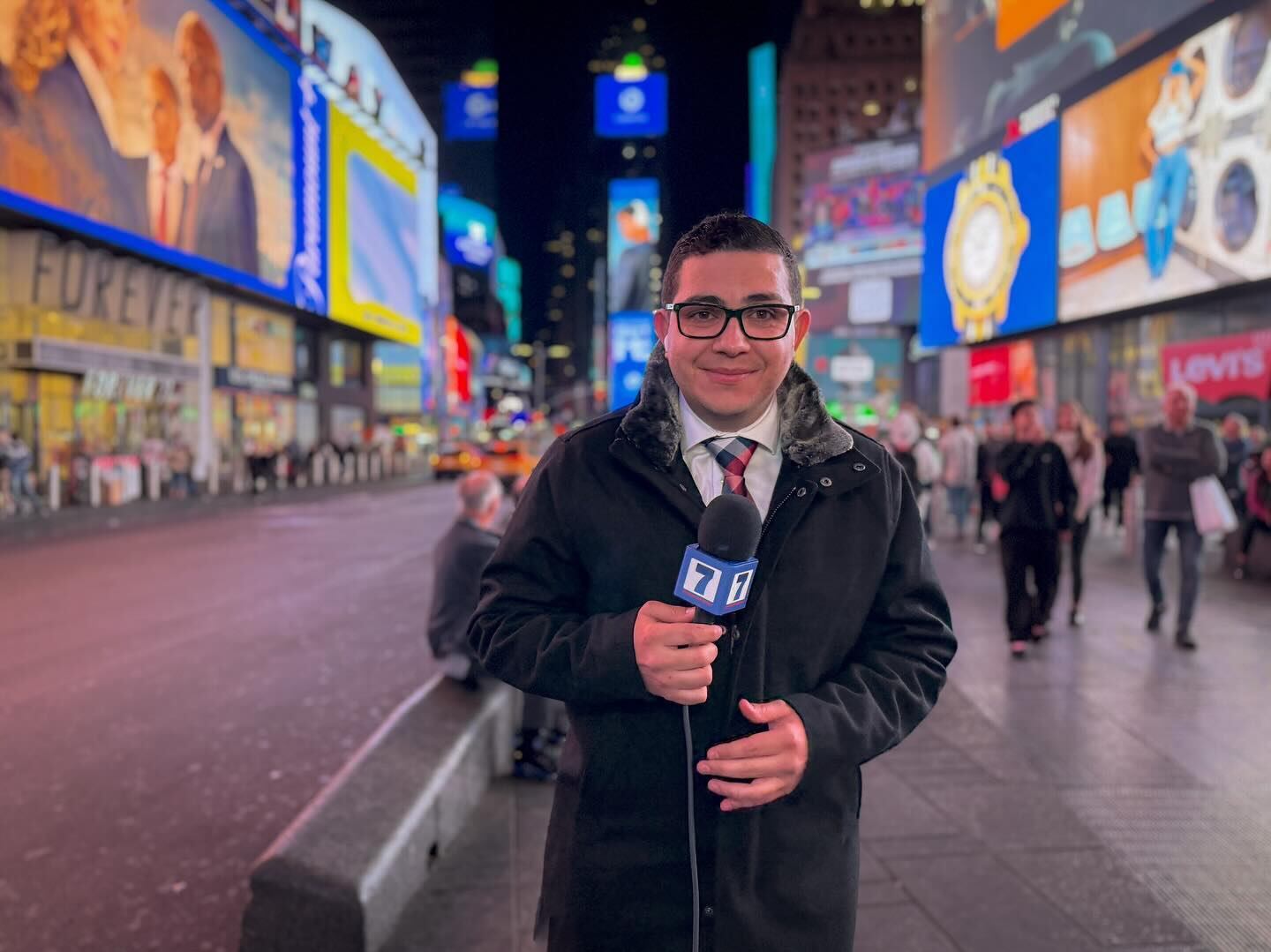 El periodista Elías Alvarado sosteniendo un micrófono de Teletica en Times Square, Nueva York.