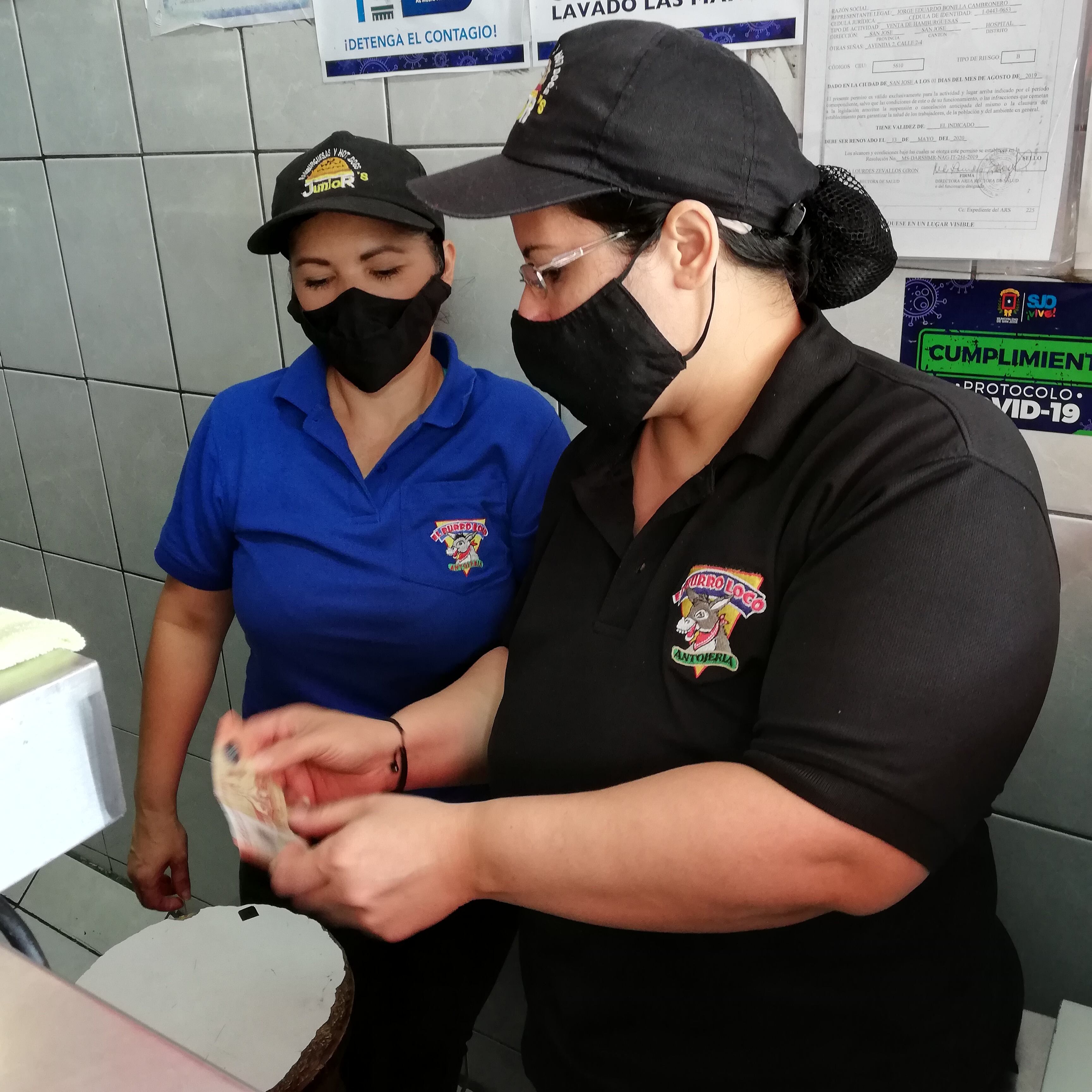 El billete de 20 córdobas de Nicaragua es gemelo del billete de 20 mil colones tico, lo que pasa es que el nicaragüense equivale a 500 colones ticos y están metiéndoselo a comercios y abuelitos. En la foto Margarita Ruiz, de Hamburguesas Junior’s, le enseña el billete de 20 córdobas a su compañera Tania Ibarra.