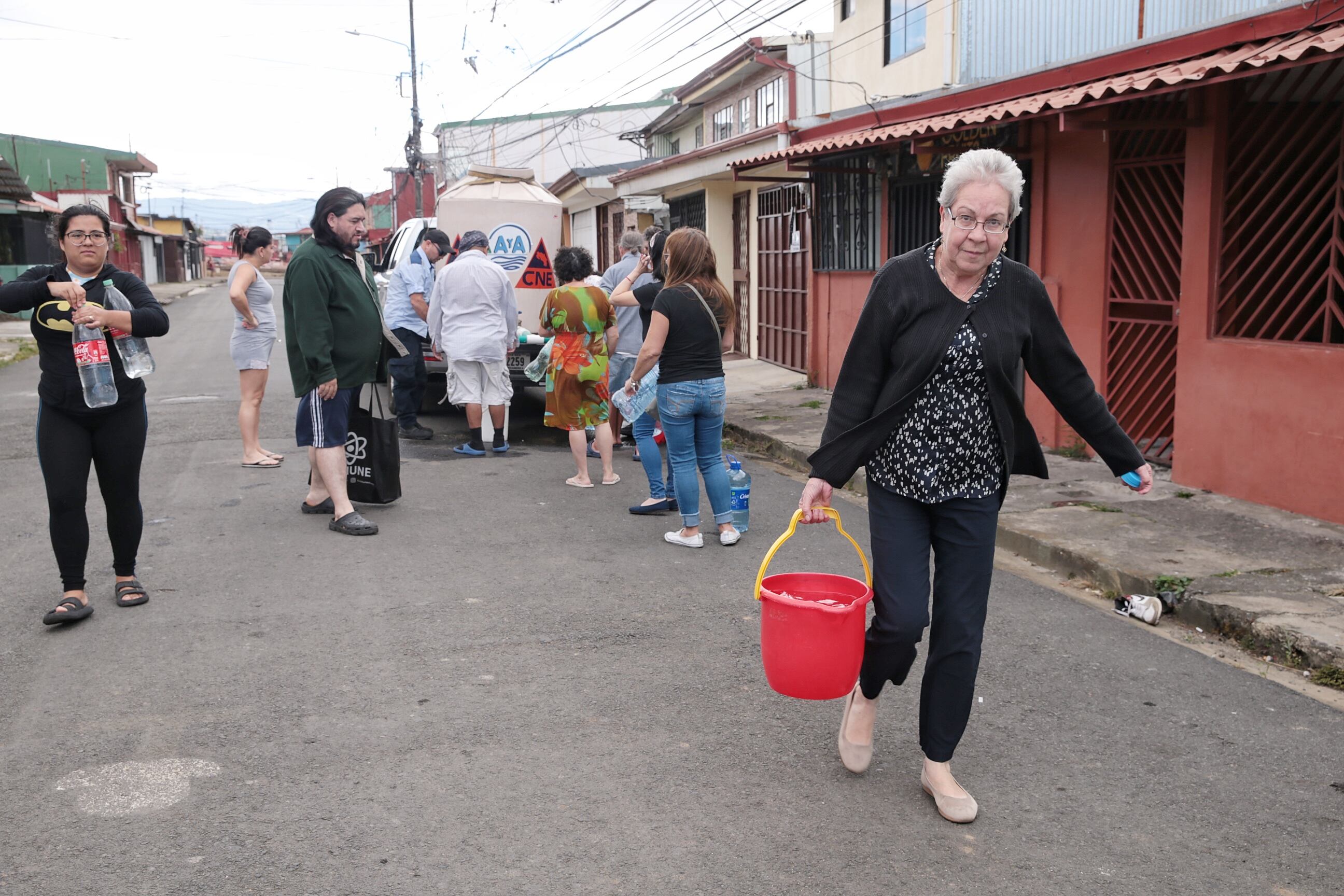 26/01/2024/ Contaminación del agua en Tibás, Moravia Guadalupe afecta a vecinos y comercio, funcionarios del A&A suministran agua en Calle Blancos / foto John Durán