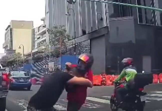 Peatón cruzó la avenida Segunda en San José con el semáforo en verde y luego golpeó en la cabeza a un motociclista, la situación quedó grabada. Foto: Captura de video