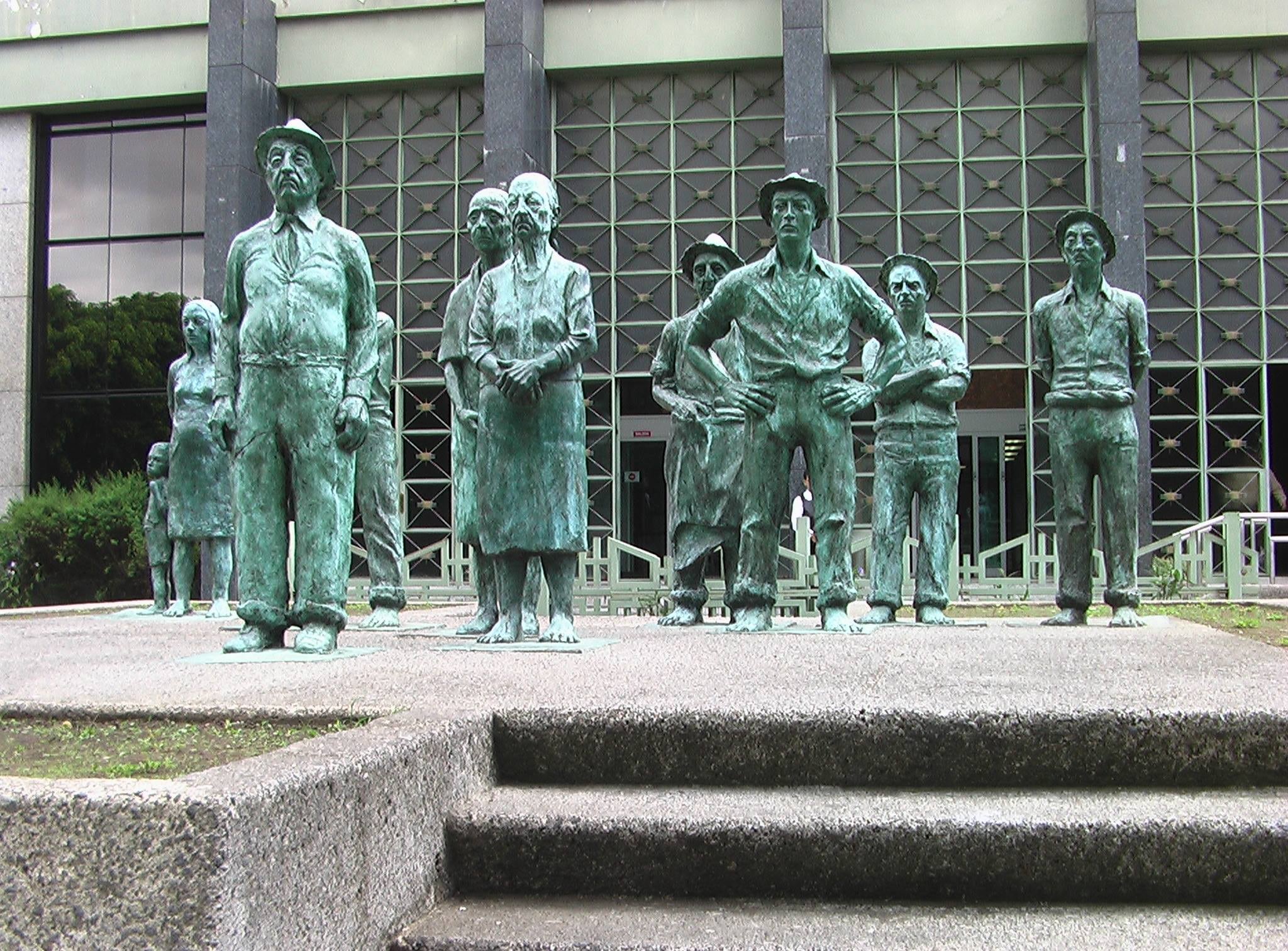 Este conjunto escultórico elaborado en bronce está compuesto por nueve figuras de tamaño natural, que representan al campesino costarricense. La obra personifica a los habitantes típicos del Valle Central, en peligro de desaparecer producto de la modernización; paradojicamente se los representa firmes, inmutables, estáticos y en silenciosa rebeldía ante los cambios.
La obra fue desarrollada por el escultor costarricense Fernando Calvo, quien recibió por su creación el Premio del Salón Anual de Escultura en 1980 y el Premio Nacional Aquileo J. Echeverría en 1982.
El conjunto escultórico "Los presentes" se encuentra en los jardines del Banco Central de Costa Rica, desde 1989 (Avenida Central y Calle 4).