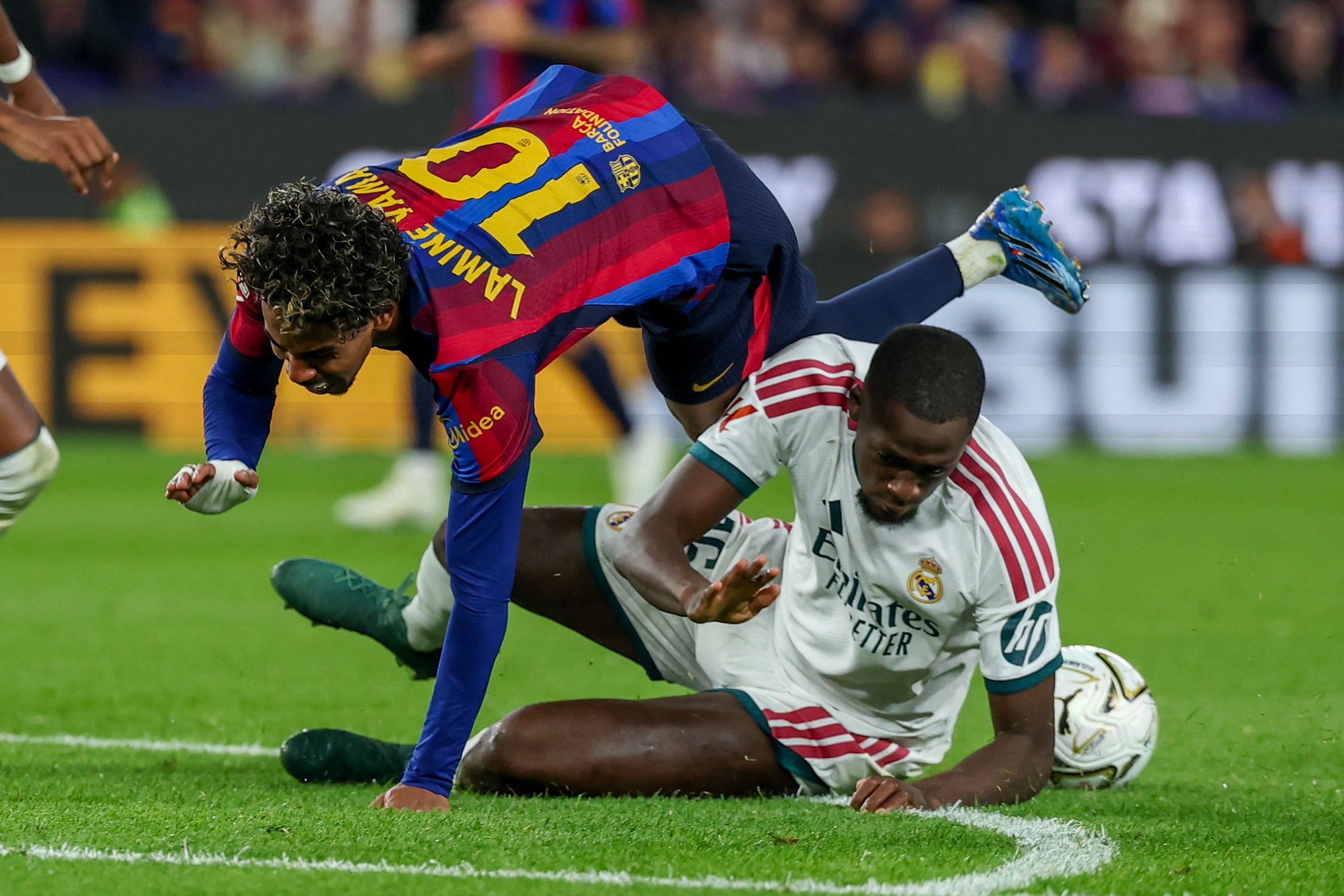 Lamine Yamal, del Barcelona, fue a dar al suelo tras el choque con Ibrahima Konate, del Real Madrid, en un cerrado clásico de la Liga Española.